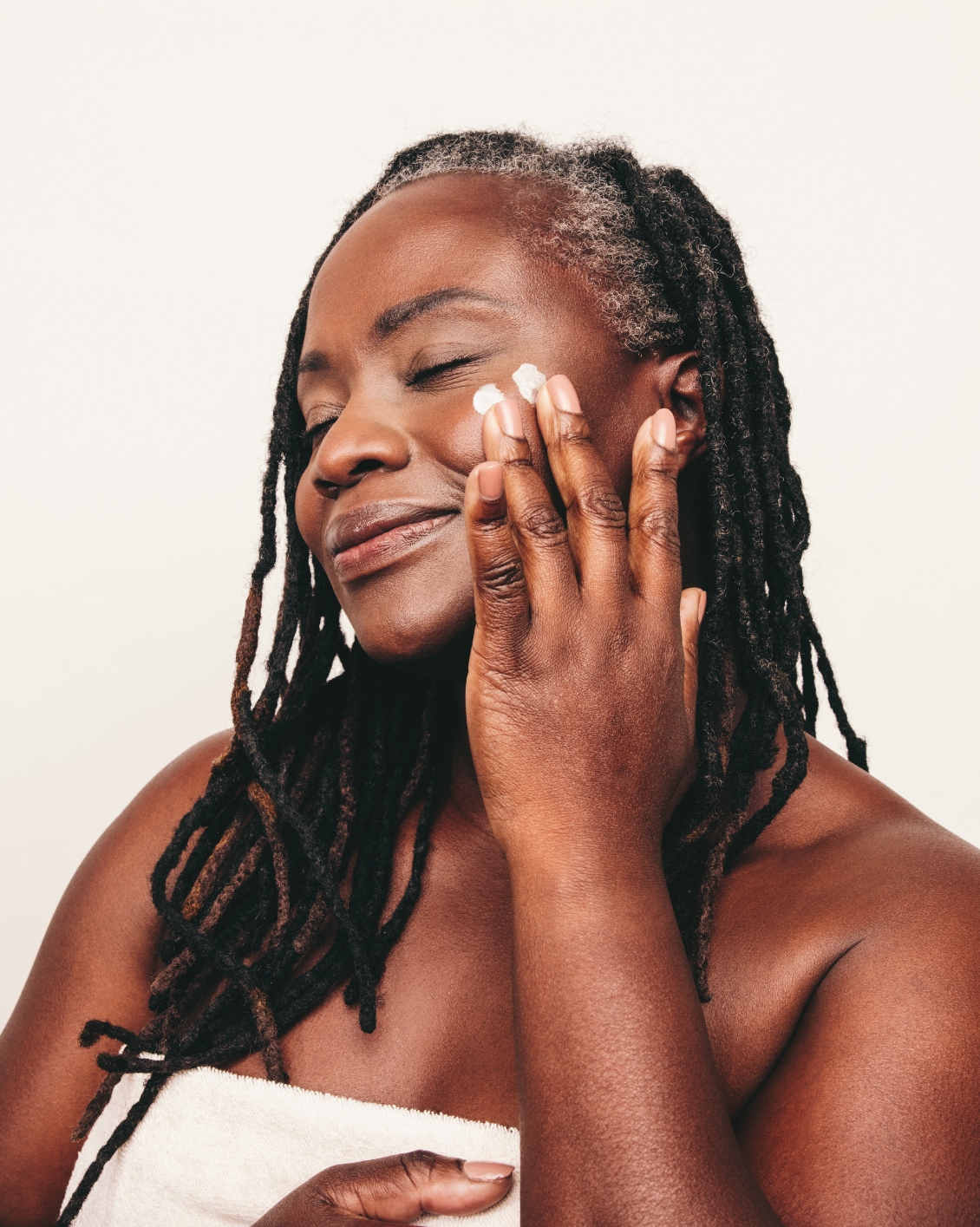 Beautiful-woman-with-dreadlocks-applying-moisturizer